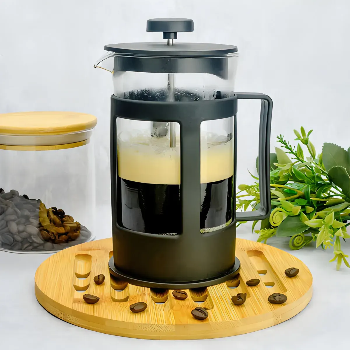 Cafetera de prensa francesa con café recién preparado y espuma cremosa