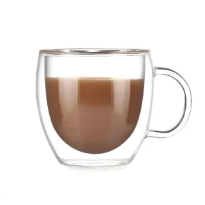 Taza de vidrio doble pared con café con leche cremoso sobre fondo blanco